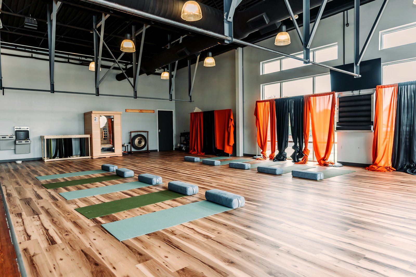 The expansive main studio with high ceilings and mats laid out